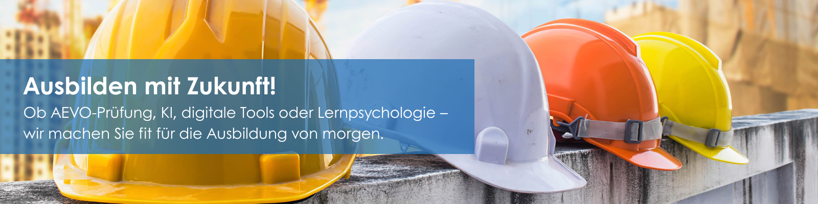 Mehrere Schutzhelme in verschiedenen Farben (gelb, weiß, orange) liegen aufgereiht auf einer Betonmauer. Text im Bild: ‚Ausbilden mit Zukunft! Ob AEVO-Prüfung, KI, digitale Tools oder Lernpsychologie – wir machen Sie fit für die Ausbildung von morgen.
